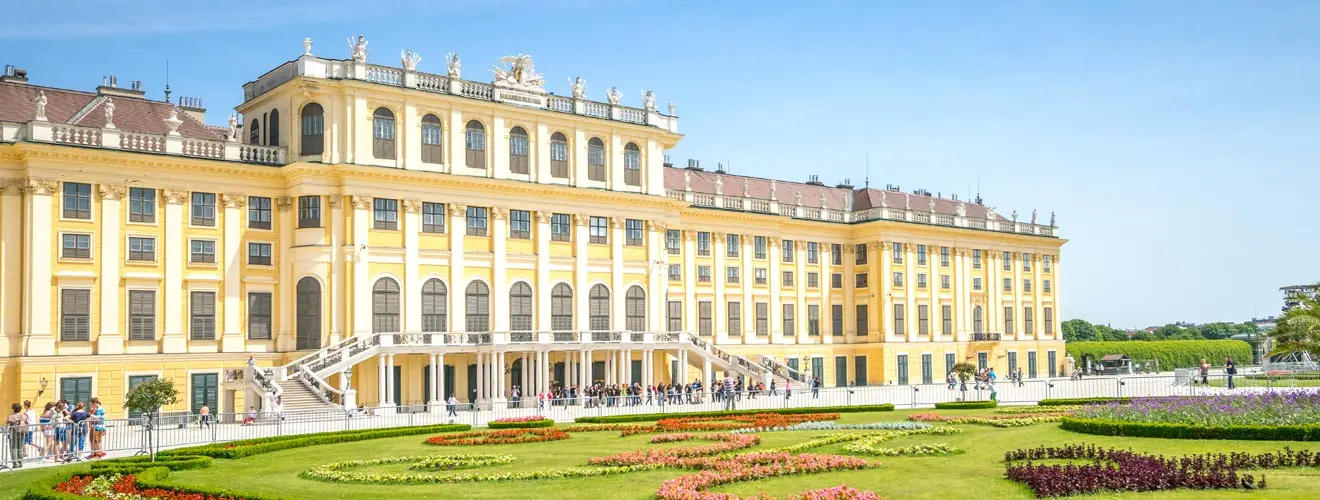 Schloss Schönbrunn in Wien mit gelber Barockfassade und blühendem Schlossgarten